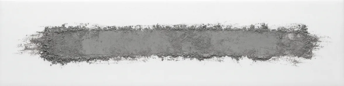 A broad horizontal smear of lead grey powder drawn across a white porcelain streak plate.